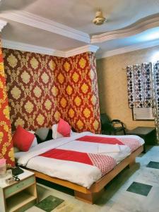 a bedroom with a bed with a red and yellow blanket at HOTEL SHREE VILLA in Harsola