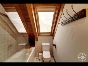 a bathroom with a toilet and a tub and a window at VARRADOS de Alma de Nieve in Naut Aran