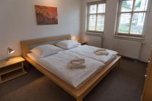 Schlafzimmer mit einem Bett mit weißer Bettwäsche und Kissen in der Unterkunft Ferienwohnungen Wollenberg in Ahlbeck