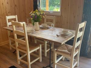 a dining room table with chairs and a wooden tableablish at Kingfisher Cabin - Wild Escapes Wrenbury off grid glamping - ages 12 and over in Baddiley