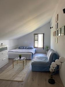 a bedroom with two beds and a couch at Tina in Tekija
