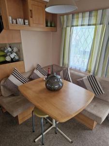 a living room with a table and a couch at Corner pitch 4 berth caravan in Ingoldmells