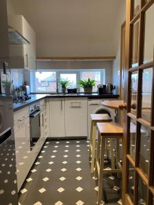 uma cozinha com armários brancos e uma mesa e cadeiras em East Road Apartment em North Berwick