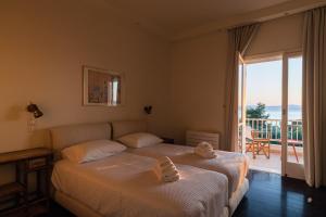 um quarto de hotel com duas camas e uma varanda em Old Sport Mansion em Mikrá Mandínia
