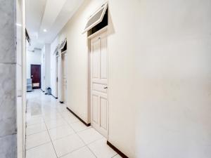 un couloir avec des murs blancs et une porte dans l'établissement OYO Life 91511 Ampel Residence Syariah, à Surabaya