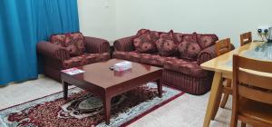 Sadaf Hotel Apartments في صحار: غرفة معيشة مع كنبتين وطاولة