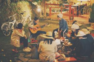 a group of people sitting around a table playing music at Nấp ở TEEPEE homestay in Da Lat