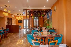 un ristorante con pareti arancioni e sedie e tavoli blu di The Village Resort Mundra a Mundra