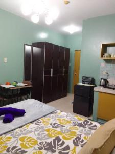 a room with a bed and a kitchen with a table at Budget Friendly Condo for Rent along Ortigas Ext in Cainta