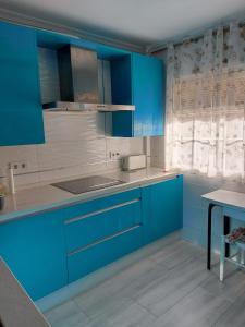 a blue and white kitchen with blue cabinets at Habitación Privada a 15 min de la Playa/Piso in Huelva