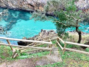 een houten hek naast een zwembad met blauw water bij Exclusiva Villa con piscina al borde del mar con vistas de película in Pechón