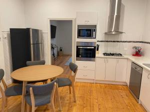 a kitchen with a wooden table and a wooden floor at Walnut House - Hargreaves St close to Lake Weeroona in Bendigo