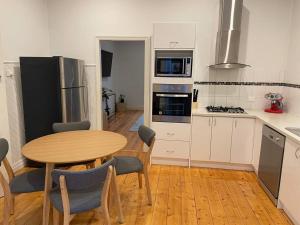 een keuken met een houten tafel en een houten vloer bij Walnut House - Hargreaves St close to Lake Weeroona in Bendigo