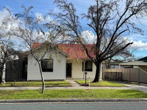 a white house with a red roof on a street at Walnut House - Hargreaves St close to Lake Weeroona in Bendigo