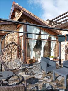 a patio with a table and chairs and a window at La Casa de los Gatos in Condemios de Abajo