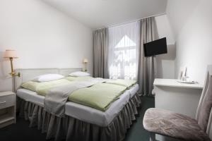 une chambre d'hôtel avec un lit et une fenêtre dans l'établissement Hotel Ferdinand, à Mariánské Lázně