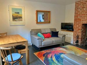 uma sala de estar com um sofá e uma mesa em Finest Retreats - Backlet Cottage - Mevagissey Cottage Sleeps 4 em Mevagissey