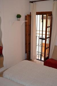 a bedroom with a bed and a sliding glass door at Apartamento completo - Centro Ciudad - Arenal in Seville +2 photos