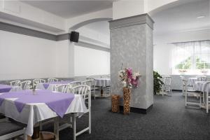 a banquet hall with purple tables and white chairs at Hotel Ferdinand in Mariánské Lázně