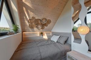 a bed in a room with wooden ceilings and windows at Osada Stara Rzeka in Stara Rzeka