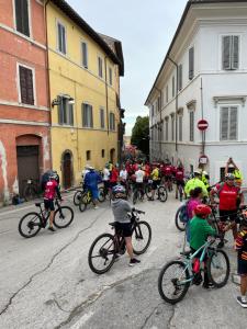 a large group of people riding bikes down a street at appartamento di via macello vecchio in Spoleto