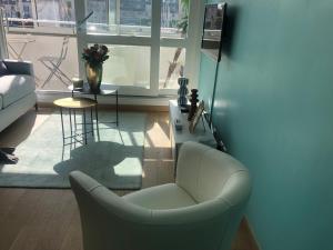 ein Wohnzimmer mit einem Stuhl und einem Fenster in der Unterkunft soleil et bateau in Courseulles-sur-Mer + 9 Fotos