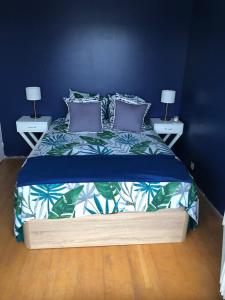1 dormitorio azul con 1 cama con 2 mesitas de noche en soleil et bateau en Courseulles-sur-Mer