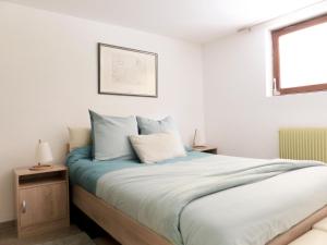Appartement entier rénové dans un écrin de verdure في تان: غرفة نوم مع سرير ووسائد زرقاء وبيضاء