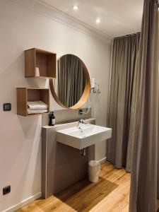 La salle de bains est pourvue d'un lavabo et d'un miroir. dans l'établissement Landhotel Augustin, à Bad Staffelstein