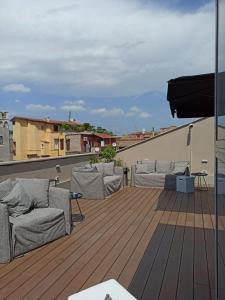 a deck with two couches on a roof at Nikis Collection Trastevere in Rome