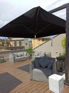 a black umbrella on top of a patio with couches at Nikis Collection Trastevere in Rome