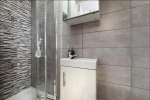 a bathroom with a white sink and a shower at Private self-contained studio close to Hampstead, Golders Green & Camden Town in London