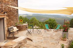 a patio with chairs and a table with a view at L'aube des Fourniels in Malbosc