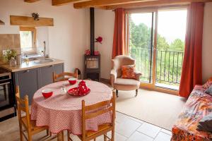 cocina y sala de estar con mesa y mantel en L'aube des Fourniels en Malbosc