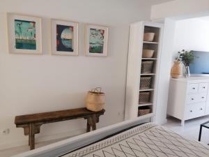 a bedroom with a bench and paintings on the wall at Townhouse Altstadt Wismar, Lower Apartment in Wismar