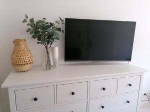 a white dresser with a television on top of it at Townhouse Altstadt Wismar, Lower Apartment in Wismar