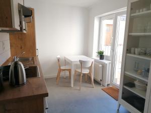 een keuken met een witte tafel en stoelen in een kamer bij Townhouse Altstadt Wismar, Lower Apartment in Wismar