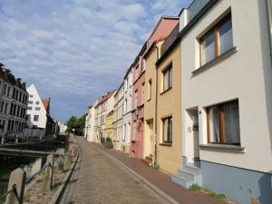 een lege straat met gebouwen naast een kanaal bij Townhouse Altstadt Wismar, Lower Apartment in Wismar