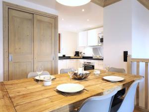 a large wooden table in a kitchen with white cabinets at Magnifique duplex 3 chambres à Courchevel avec balcon, parking, et WIFI - FR-1-575-107 in Courchevel