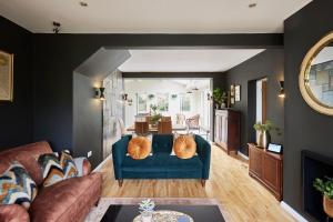 a living room with a blue couch and a dining room at Lux Central Whitby Near Pannett Park/Cinder Trail in Whitby