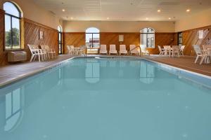 uma piscina num hotel com cadeiras e mesas em Ramada by Wyndham Strasburg Dover em Strasburg