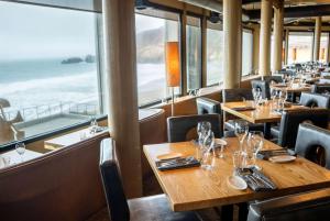a restaurant with tables and chairs and a view of the ocean at Pacifica Lighthouse Hotel Trademark Collection by Wyndham in Pacifica