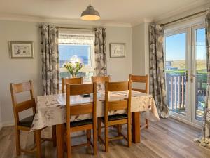 a dining room with a table and chairs and a window at Lingeigh in Pollachar