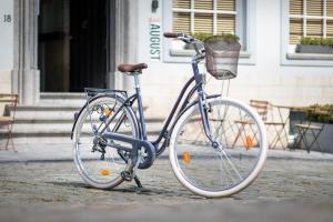 a blue bike with a basket parked on the street at Hotel Augustyn Brugge in Bruges