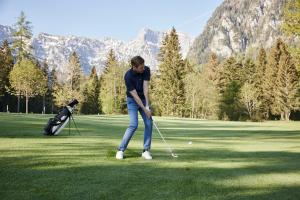 un hombre está jugando golf en un campo de golf en Der Brandstetterhof - Adults only, en Stans