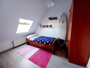 Dormitorio pequeño con cama y espejo en Duplex con piscina muy cerca de la playa, en Santiuste