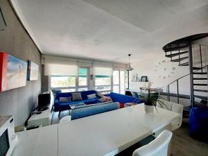 a living room with a blue couch and a table at Duplex con piscina muy cerca de la playa in Santiuste