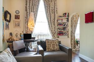 een woonkamer met een bank, een tafel en een raam bij Charming one bedroom flat near Maida Vale by UnderTheDoormat in Londen