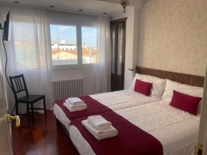 um quarto com uma cama grande e toalhas em La Terraza de los Infantes em Zamora