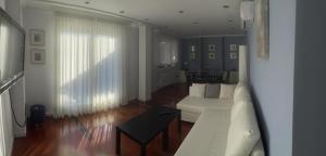 a living room with a white couch and a table at La Terraza de los Infantes in Zamora
